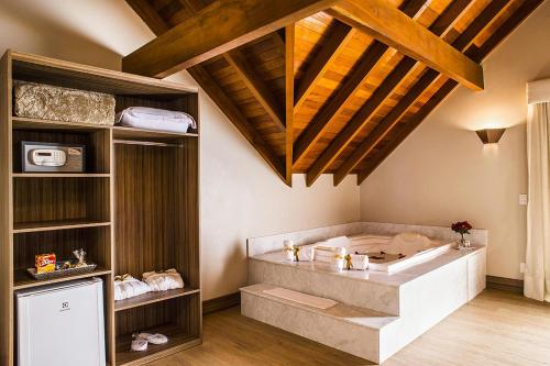 グラマドにあるHotel Refugio da Montanhaの木製の天井の客室で、バスタブが付いています。