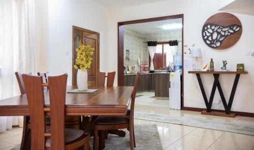 a dining room with a wooden table and chairs at ZaNaKri Homes ;A Great Panorama of Indian Ocean in Mombasa
