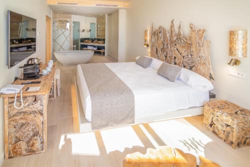 a bedroom with a large bed with a wooden headboard at Zahara Beach & Spa by QHotels - Adults Recommended in Zahara de los Atunes