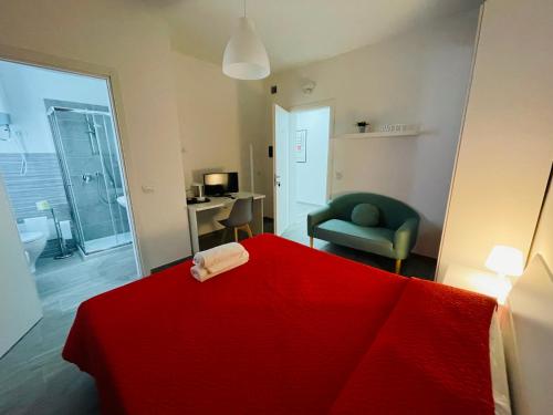 una camera con letto rosso e sedia verde di La cittadella rooms a Monserrato