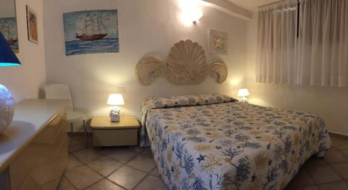 a bedroom with a bed and a table and two lamps at Sardegna Beach Eucalyptus in Golfo Aranci