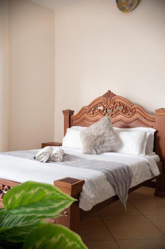 a bedroom with a bed with white sheets and pillows at ZaNaKri Homes ;A Great Panorama of Indian Ocean in Mombasa