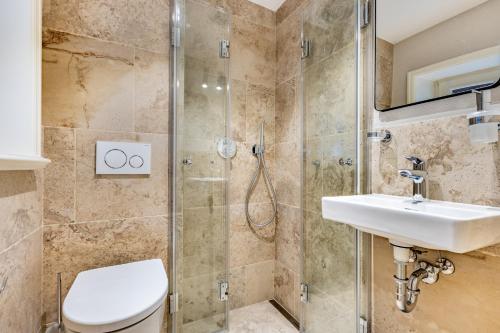 een badkamer met een toilet, een wastafel en een douche bij Ferienhaus Luv in Munkmarsch