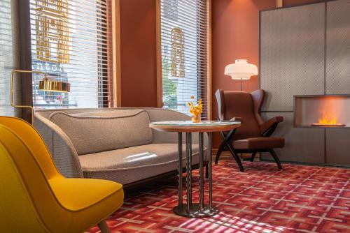 a waiting room with a couch and chairs and a table at Hotel Yllen Eiffel in Paris