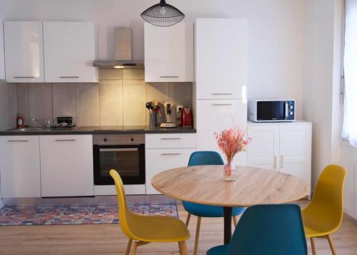 een keuken met een houten tafel en stoelen bij Zum Milhüsa - Rénové en 2021 in Mulhouse