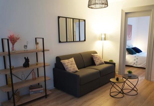 een woonkamer met een bank en een spiegel bij Zum Milhüsa - Rénové en 2021 in Mulhouse