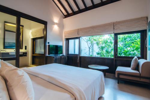 a bedroom with a large bed and a large window at Three Gables Boutique Villa in Mirissa