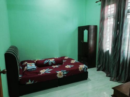una camera da letto con un letto fiorito di Tiffana Homestay a Kampong Ayer Terjun
