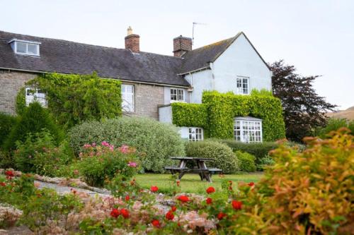 a house with a picnic table in a garden at The Izaak Walton Country House Hotel in Ashbourne