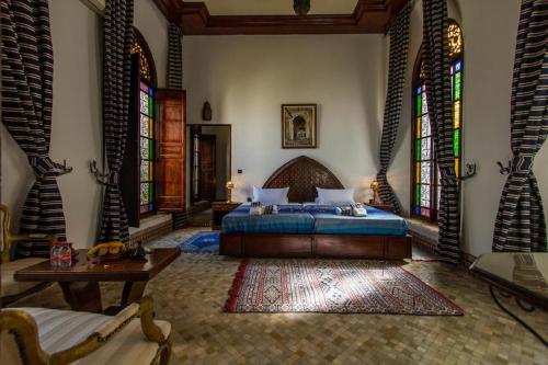 a bedroom with a bed and stained glass windows at Pacha Palace in Fès