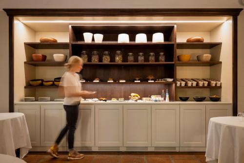 a woman is standing in front of a counter at Le Prieure in Villeneuve-lès-Avignon