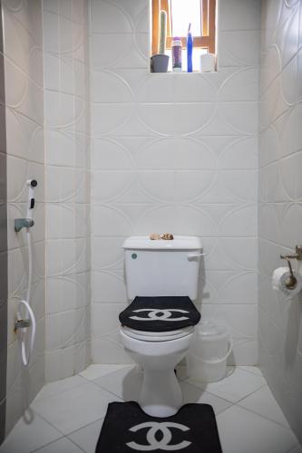 a bathroom with a toilet with a black and white lid at ZaNaKri Homes ;A Great Panorama of Indian Ocean in Mombasa