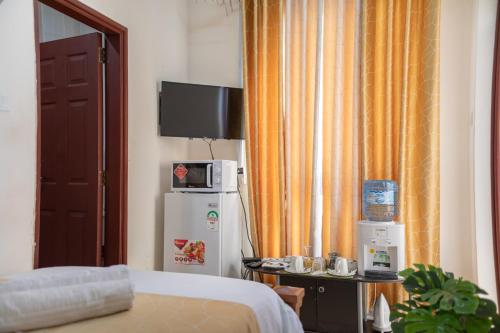a hotel room with a bed and a refrigerator at ZaNaKri Homes ;A Great Panorama of Indian Ocean in Mombasa