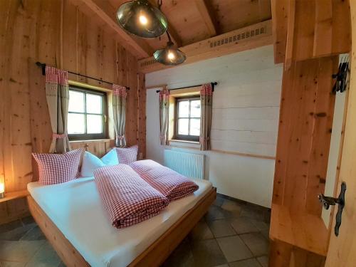 a room with a bed in a wooden house at Bio & Reiterhof der Veitenhof - Pferde, Berge, Wellness & Freiheit im Ötztal in Niederthai