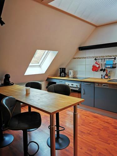 une cuisine avec une table en bois et quelques chaises dans l'établissement Mirabeau, à Le Mont-Dore