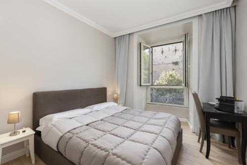 a bedroom with a bed and a desk and a window at Rhome Hosting in Rome