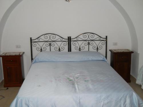 łóżko z białą narzutą z kwiatami w obiekcie Agriturismo Tenuta Perruzzi w mieście Leverano