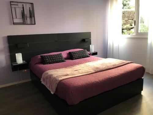 ein Schlafzimmer mit einem großen Bett mit rosa Bettwäsche und Kissen in der Unterkunft Ade Home in Catania