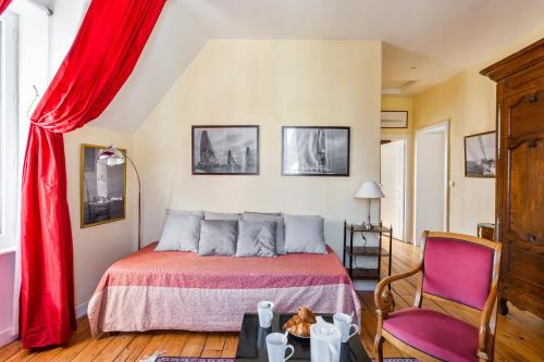 a bedroom with a bed and a red curtain at Kereden Location in Saint Malo