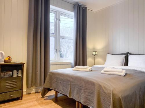 una camera da letto con un letto grande con due asciugamani sopra di Båtsfjord Brygge - Arctic Resort a Båtsfjord