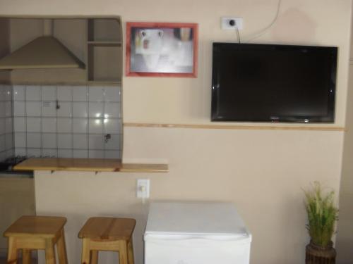 a kitchen with a flat screen tv on the wall at Hotel De La Rue in Buenos Aires