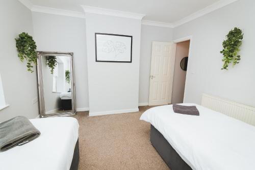 Habitación blanca con 2 camas y espejo. en Newly Refurbished House - 10 Minute Walk From City Centre en Norwich