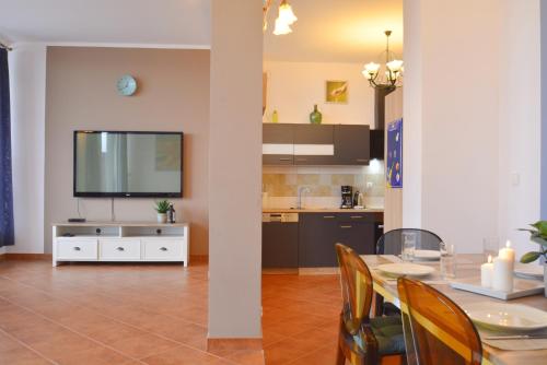 a kitchen and dining room with a table and a television at Villa Concha-Apartamenty Bryza-Parking in Świnoujście