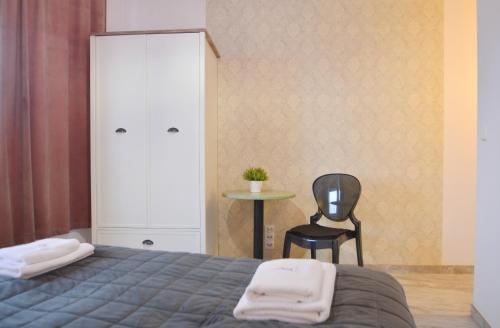 a bedroom with a bed and a chair and a cabinet at Villa Concha-Apartamenty Bryza-Parking in Świnoujście