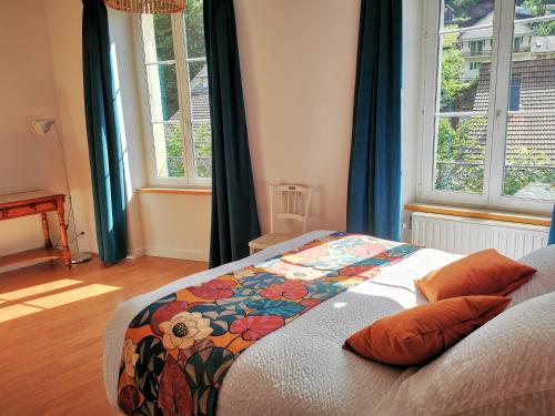- une chambre avec un lit doté d'une couette en fleurs dans l'établissement Mirabeau, à Le Mont-Dore