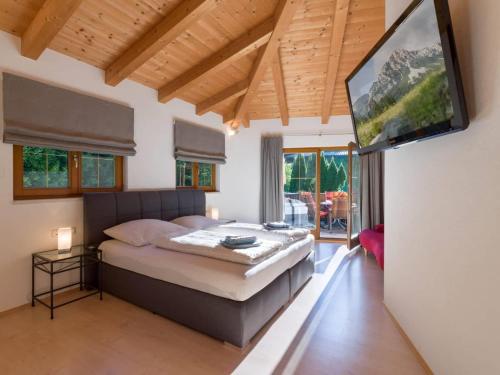 a bedroom with a bed and a flat screen tv at Ferienwohnung Pacher in Hopfgarten im Brixental