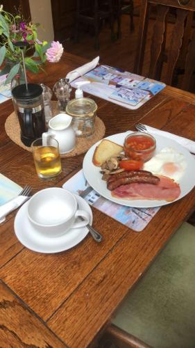 a wooden table with a plate of food on it at The Black Horse Inn in Canterbury