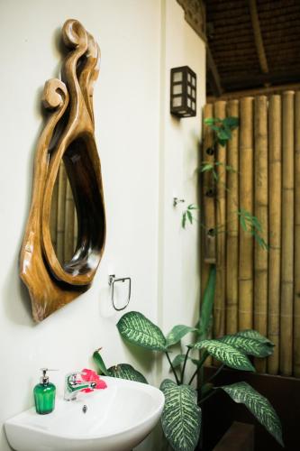 a bathroom with a sink and a mirror on the wall at Fox & The Firefly Cottages in Loboc