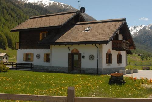 a small house in a field with mountains in the background at Baita sulle Alpi Livigno in Livigno