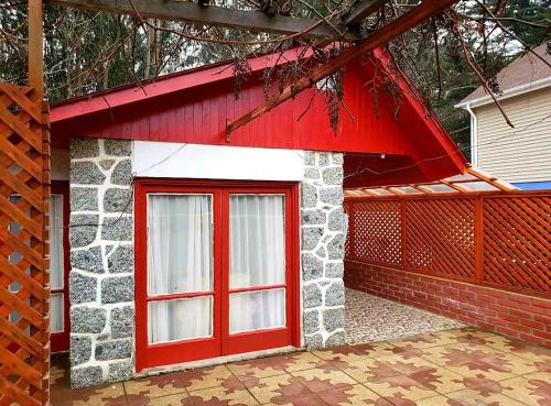 une porte rouge sur un bâtiment avec un toit rouge dans l'établissement Casa Isla Negra, à Isla Negra
