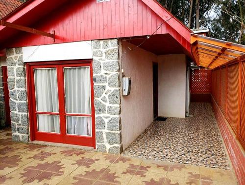czerwone drzwi domu z czerwonym dachem w obiekcie Casa Isla Negra w mieście Isla Negra