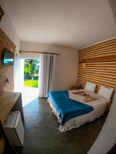 a bedroom with a large bed and a large window at Pousada Barra Trip in Barra Grande