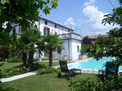 a villa with a swimming pool and a house at Maison Fortune in Castelnuovo del Garda