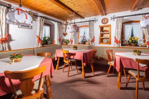 Un restaurante con mesas y sillas en una sala. en Gästehaus Untersulzberglehen, en Schönau am Königssee