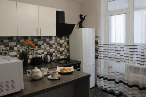 eine Küche mit einem Kühlschrank und einem Teller mit Lebensmitteln auf der Theke in der Unterkunft Квартира в Вышгороде для души in Wyschhorod