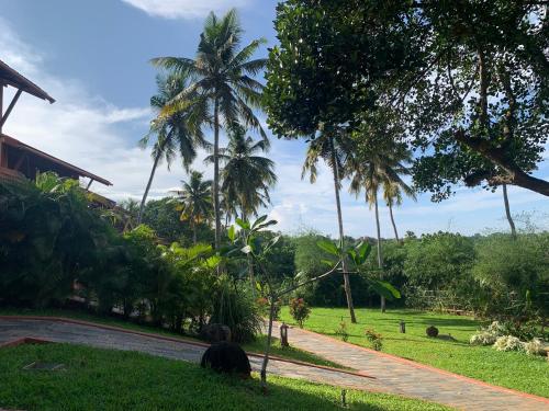 a road with palm trees on the side of a house at AMARA AYURVEDA RETREAT- Overlooking Evergreen Western Ghats an ecologically sustainable living space in Kovalam in Kovalam