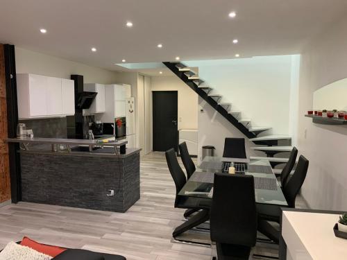 a living room with a staircase with black chairs at Beau duplex 90m2 au calme in Buchères