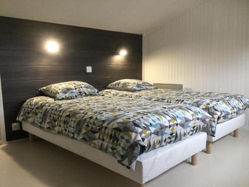 une chambre avec un grand lit avec une tête de lit noire dans l'établissement Hébergement à l'Orée des Champs, à Rethel