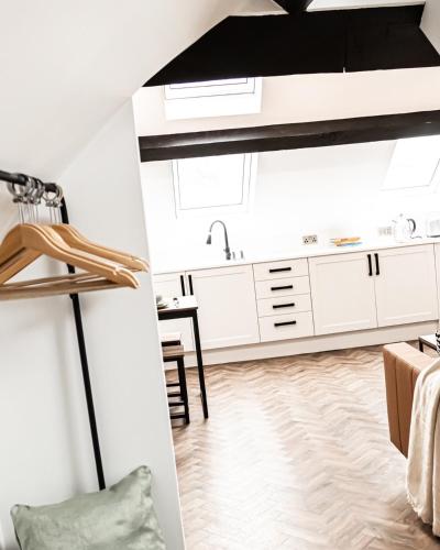 a kitchen with white cabinets and a black ceiling at Urban Loft Apartment • 1 Bedroom • Manchester in Ashton under Lyne