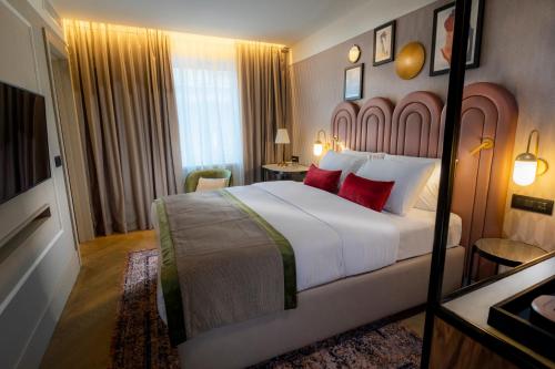 a hotel room with a large bed with red pillows at Hotel Indigo Belgrade by IHG in Belgrade