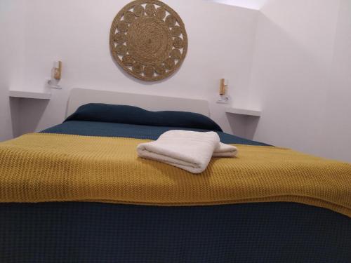 a bed with a yellow blanket and a picture on the wall at Apartamento Ajuy in Ajuy