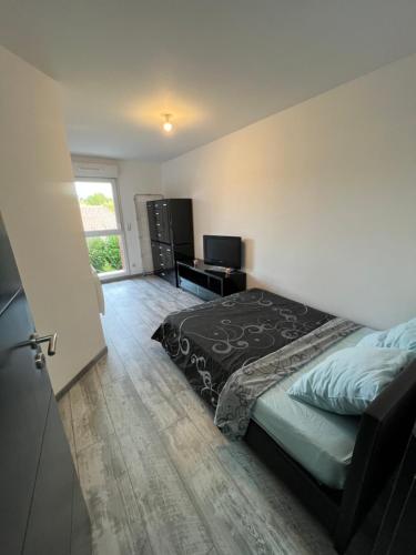 a bedroom with a bed and a television in it at Beau duplex 90m2 au calme in Buchères