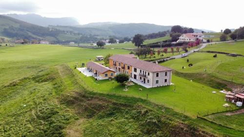 an aerial view of a house on a green field at Apartamentos Rurales Sobremazas in Sobremazas