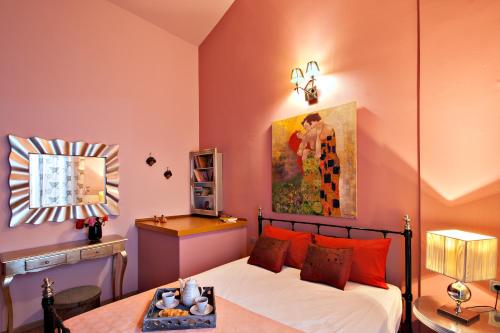 une chambre avec un lit avec un tableau sur le mur dans l'établissement Kaiti`s House, à Skiathos Chora