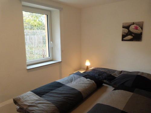 1 cama en un dormitorio con ventana en ATELIER IM STADTGARTEN 2 direkt in Rottweil, en Rottweil