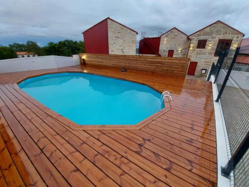 a large swimming pool on a deck with a fence at Casa de Penedones - Ventos do Larouco in Penedones